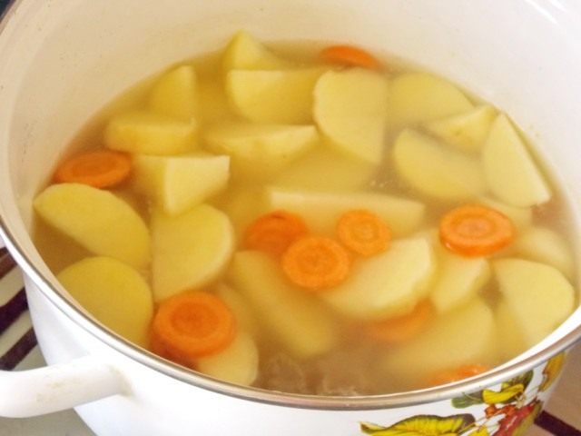 Выкладываем в кастрюлю картофель и морковь и ставим тушиться