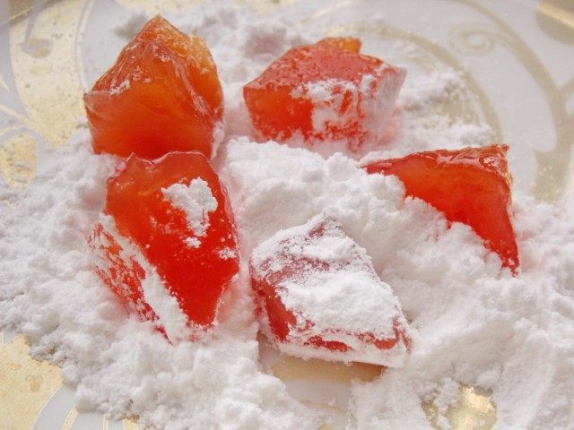 Правильно подсушенные цукаты из айвы обваливаем в сахарной пудре