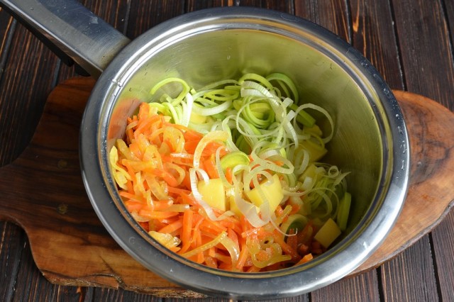 Выкладываем пассерованные овощи, картофель и лук-порей в кастрюлю