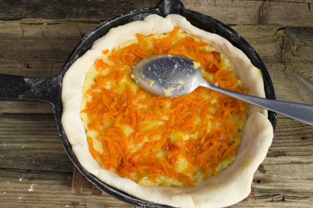 На тесто выкладываем картофель, а сверху – отваренную морковь