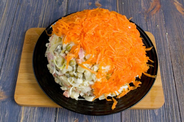 Натираем оставшуюся морковь и покрываем ею салат