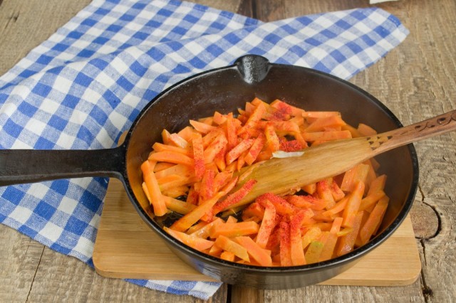 Выкладываем мясо со сковородки, на его место отправляем морковь
