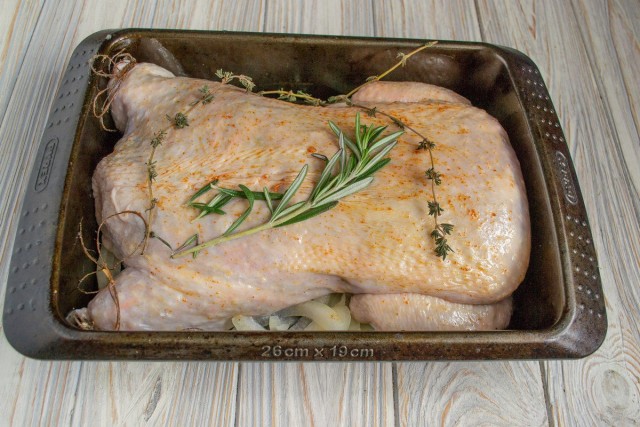 Смазываем курицу растительным маслом, натираем паприкой, кладём в форму, добавляем веточку розмарина и тимьяна
