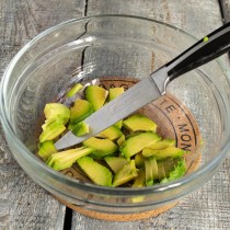 Режем авокадо тонкими ломтиками и кладём в салатницу