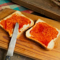 Для сэндвича с мясом и капустой смазываем поджаренные тосты кетчупом