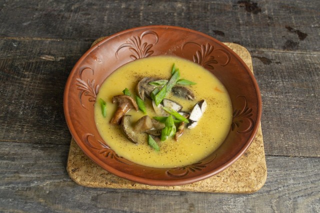 Наливаем грибной крем-суп, перчим, посыпаем зелёным луком
