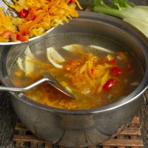 Добавляем обжаренные овощи, доводим суп до кипения, убавляем нагрев и закрываем крышкой