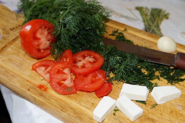 Нарежьте зелень, томаты, чеснок и сыр небольшими кусочками