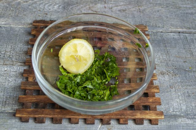 Для заправки кладём измельченную зелень в миску, выжимаем сок из половинки лимона