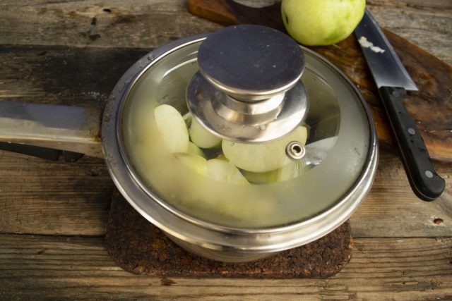 Наливаем в сотейник 2-3 ст. л. воды, кладём яблоки, закрываем крышкой и ставим на плиту