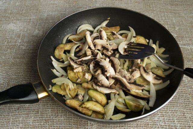 К обжаренным овощам добавляем нарезанные грибы, посыпаем солью, тушим 10 минут