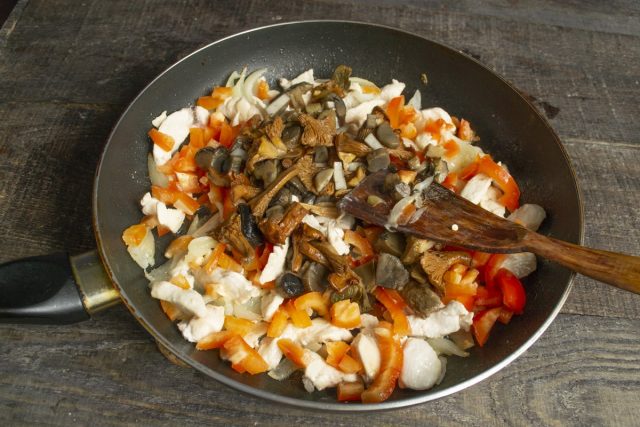 Кладём нарезанные грибы в сковородку, перемешиваем, готовим на среднем огне 10 минут