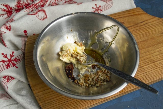 Смешиваем в миске размягченное масло, мёд, мелко порубленные грецкие орехи и соевый соус