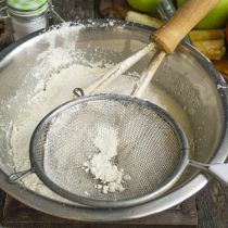 Муку, пекарский порошок и соду просеиваем, добавляем к жидким ингредиентам и перемешиваем