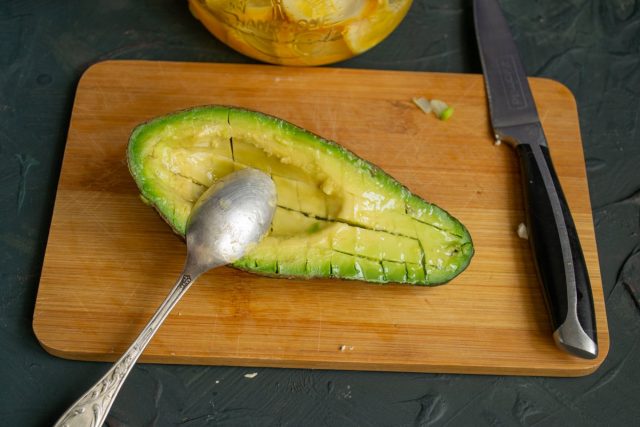 Половину авокадо нарезаем мелкими кубиками прямо в кожуре, поливаем соком лайма и выворачиваем