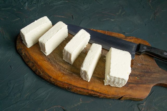Брусок адыгейского сыра нарезаем ломтиками толщиной примерно 1.5-2 сантиметра