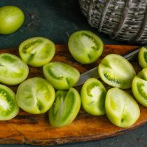 Тщательно моем помидоры, разрезаем пополам, вырезаем уплотнение возле плодоножки