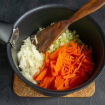 Морковь шинкуем тонкой соломкой, добавляем к сельдерею и луку