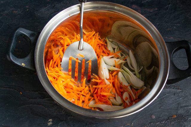 Кладём в разогретое масло сначала лук, через полминуты чеснок, затем добавляем тёртую морковку