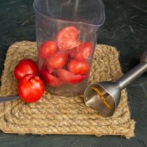 Нарезаем помидоры, кладём в высокий стакан блендера