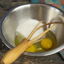 Смешиваем в миске свежие куриные яйца и сахар, добавляем щепотку соли