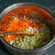 Натираем морковь и кладём в кастрюлю к нарезанным овощам