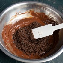 Снимаем растопленный шоколад с водяной бани, добавляем крошки печенья