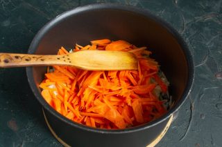 Добавляем шинкованную морковь, готовим овощи на среднем огне