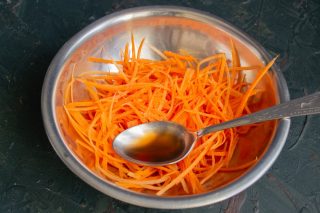 Натираем морковь на тёрке для овощей по-корейски и приправляем