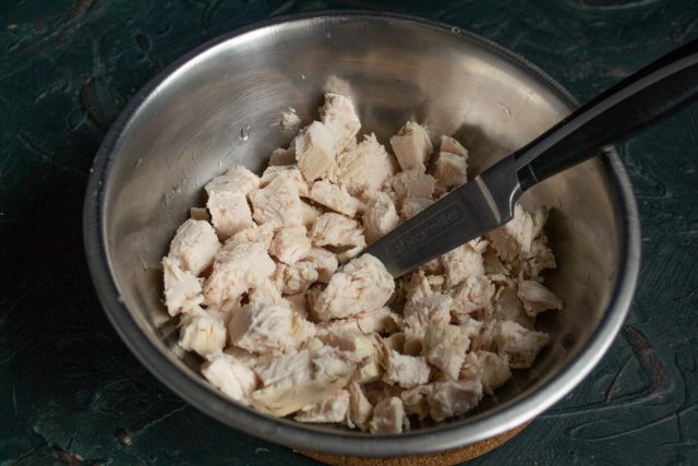 Варёное куриное филе нарезаем кубиками или разрываем на волокна