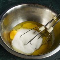 Разбиваем в миску куриные яйца, добавляем мелкий сахарный песок, щепотку соли и ванилин