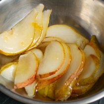 Нарезаем груши, добавляем лимонный сок, лимонную цедру и мёд, перемешиваем