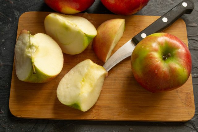 Тщательно моем яблоки, разрезаем на части, вырезаем серединку с семенами