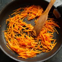 Морковь режем соломкой и высыпаем в сковороду, обжариваем до мягкости