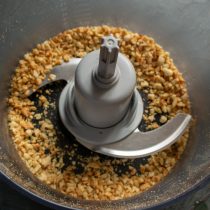 Измельчаем орехи в блендере в крошку. Вместо блендера можно использовать скалку и полотенце 