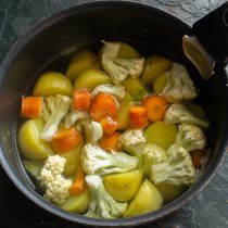 Когда картофель сварится до полуготовности, добавляем морковь и цветную капусту