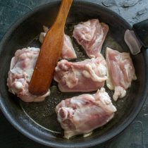 Курицу смазываем растительным маслом, выкладываем на горячую сухую сковороду кожей вниз