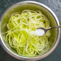 Кладём кабачковые спагетти в большую миску, солим