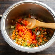 Нарезаем помидоры мелко, отправляем в кастрюлю к морковке с луком