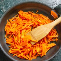 Морковь скоблим, режем тонкой соломкой или натираем на крупной терке. Обжариваем морковь до мягкости на небольшом огне, солим.