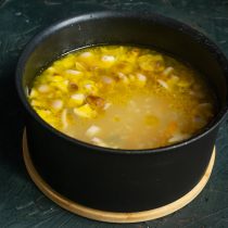 Примерно через 30 минут кладём в кастрюлю с супом нарезанную картошку, снова быстро доводим до кипения