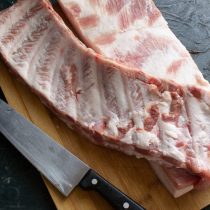 Острым ножом срезаем ребра с грудинки, прихватив солидный кусок мяса