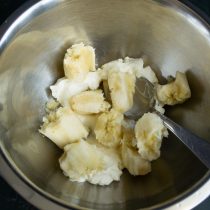 Спелый банан ломаем на кусочки, добавляем в миску к творожному сыру.