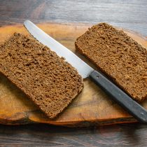 Отрезаем два тонких ломтика ржаного хлеба из цельнозерновой муки.