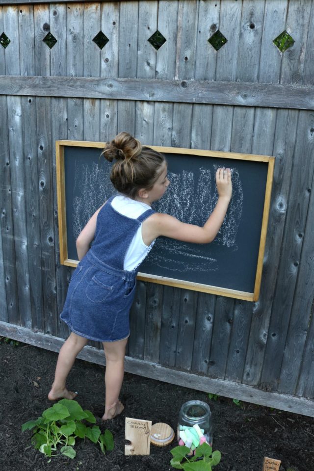 Девочка рисует на меловой доске