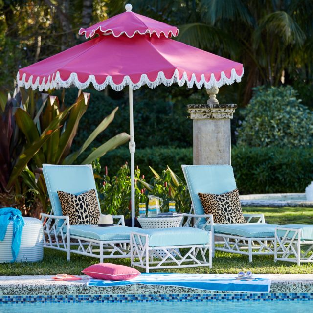 Pink parasol with two tiers above the sun loungers