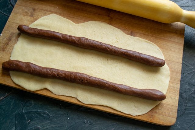 Выкладываем колбаски на раскатанный лист на расстоянии 10 сантиметров друг от друга