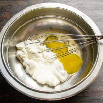 В миску разбиваем куриные яйца, добавляем жирную сметану и сахар