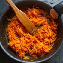 Кладём тёртую морковку в сковороду, посыпаем солью и сушеным тимьяном