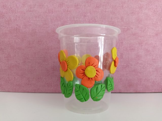 Изготавливаем из пластилина цветы, выбираем максимально тёплые оттенки и декорируем стаканчик в весеннем стиле